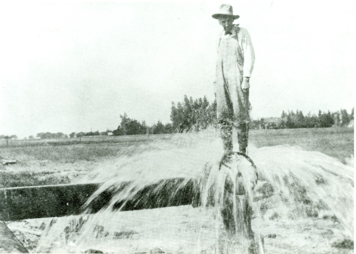 old photo of man standing on pipe