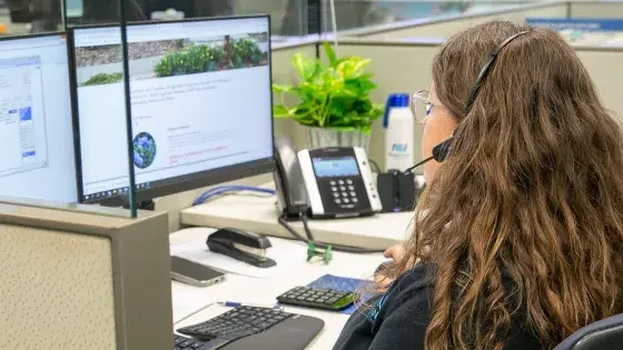 A woman facing a computer screen while on a support call.