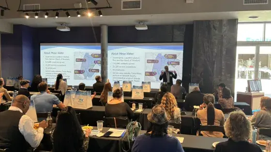 Water Issue Study Group: image contains a group of people looking at a PowerPoint presentation on a white board. 